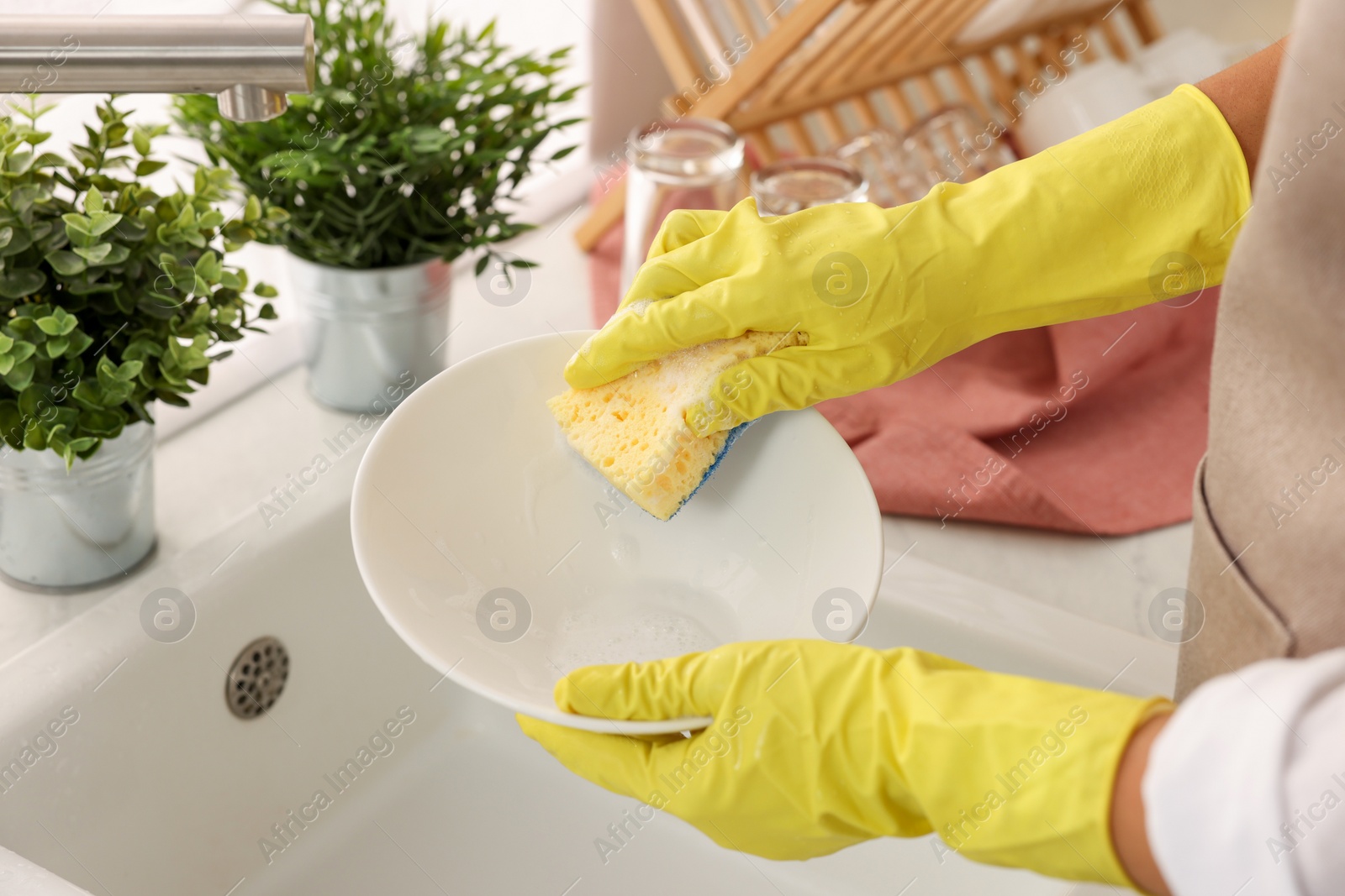 Photo of Woman washing bowl at sink in kitchen, closeup