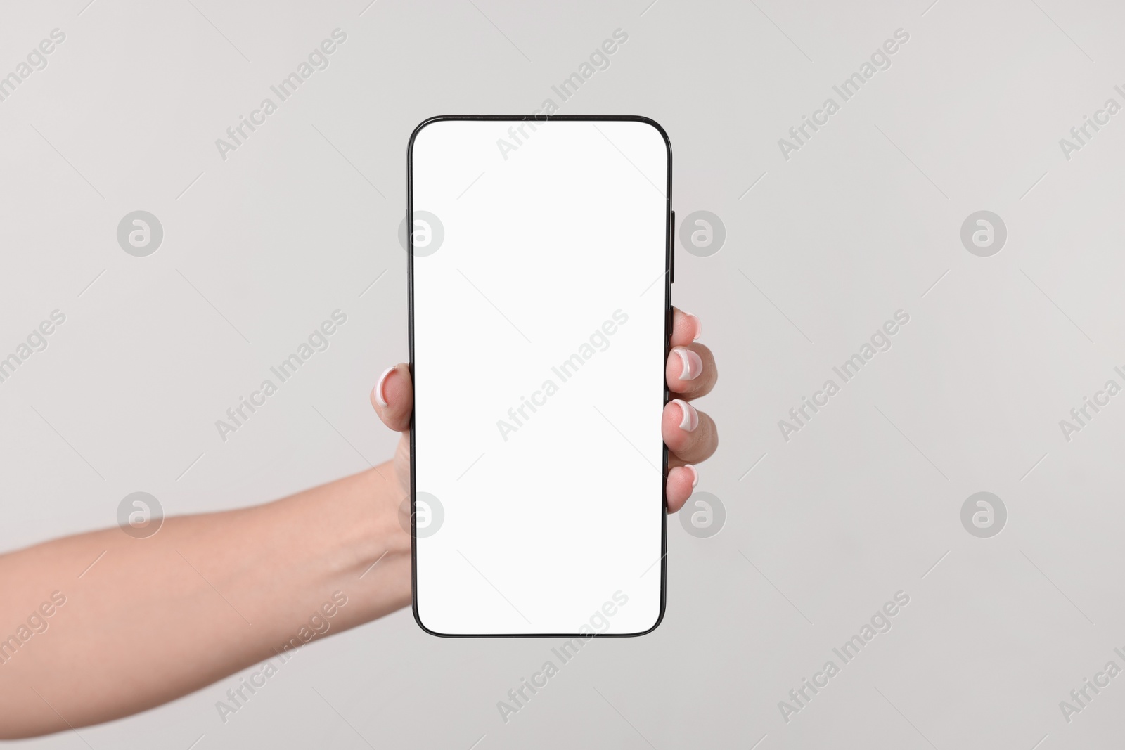 Photo of Woman holding smartphone with blank screen on light grey background, closeup. Space for text