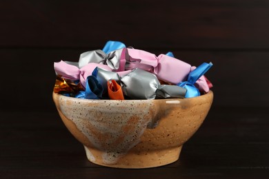 Candies in colorful wrappers on wooden table