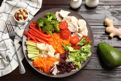 Photo of Balanced diet and healthy foods. Plate with different delicious products on dark wooden table, flat lay