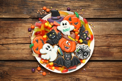 Tasty cookies and sweets for Halloween party on wooden table, top view