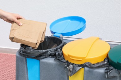 Photo of Woman throwing cardboard in bin outdoors, closeup. Recycling concept