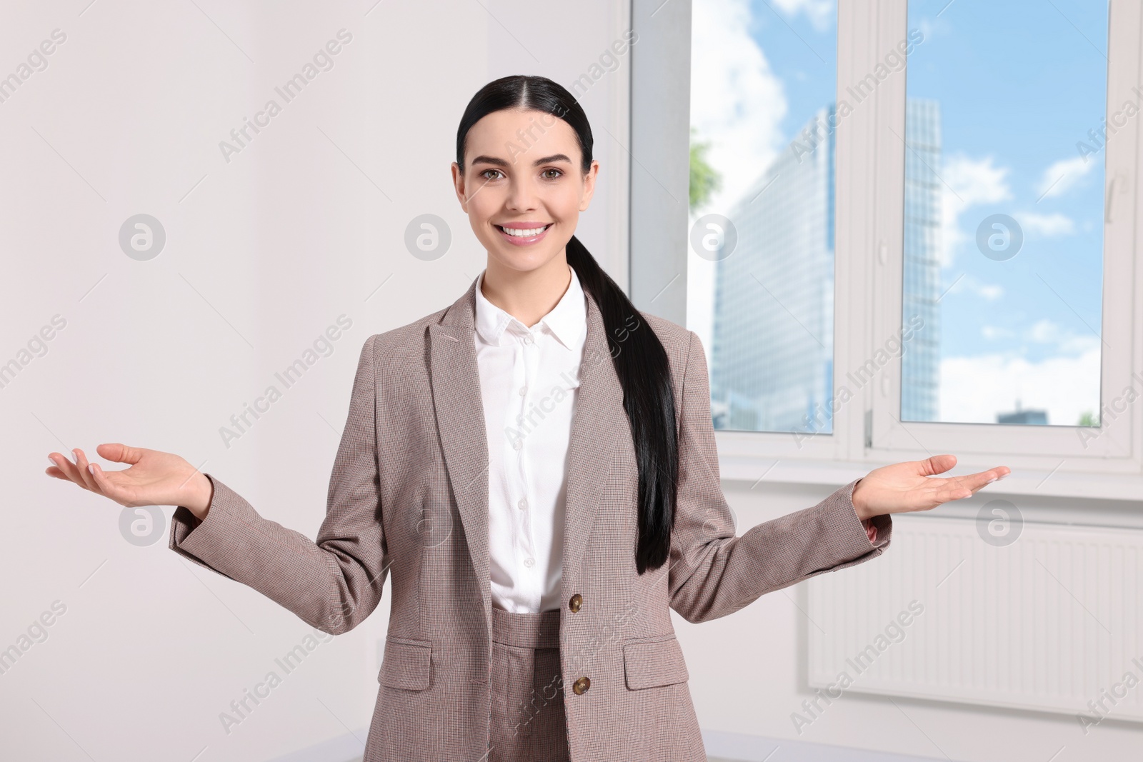 Photo of Beautiful real estate agent in nice suit indoors