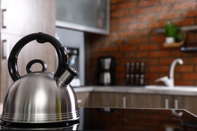 Modern kettle with whistle on stove in kitchen, space for text