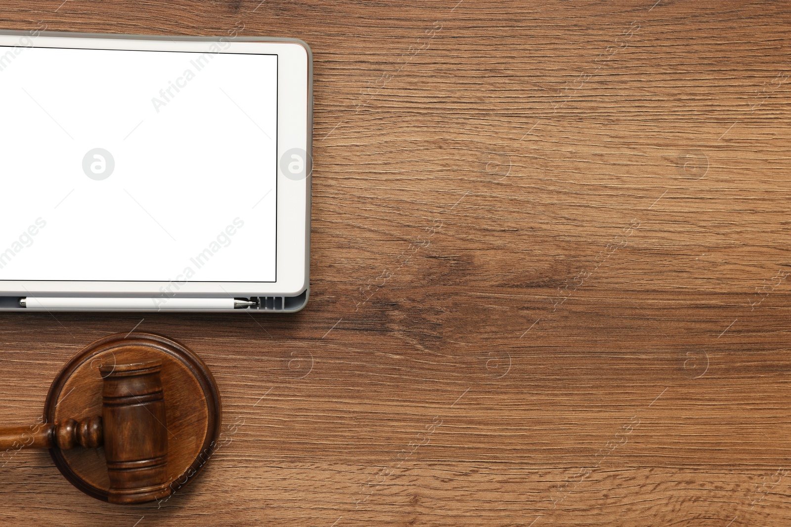 Photo of Modern tablet and gavel on wooden table, flat lay. Space for text