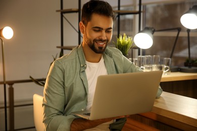 Photo of Man working with laptop at table in cafe