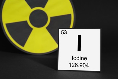 Card with chemical element Iodine and radiation sign on black background. Space for text
