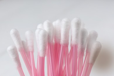 Photo of Many cotton buds on white background, closeup