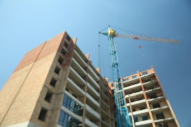 Photo of Blurred view of unfinished building and tower crane outdoors