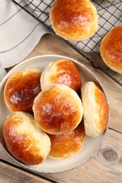 Photo of Tasty scones prepared on soda water on wooden table, flat lay