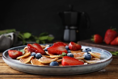 Photo of Cereal pancakes with berries on wooden table