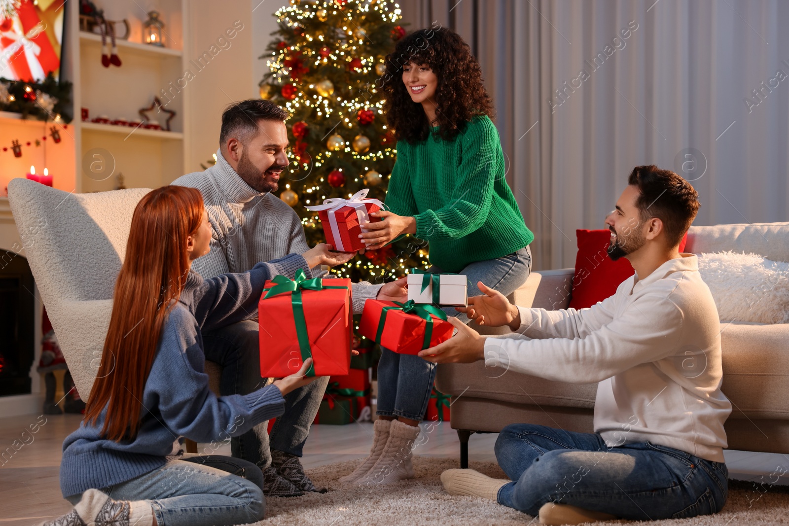 Photo of Christmas celebration. Happy friends exchanging gifts at home