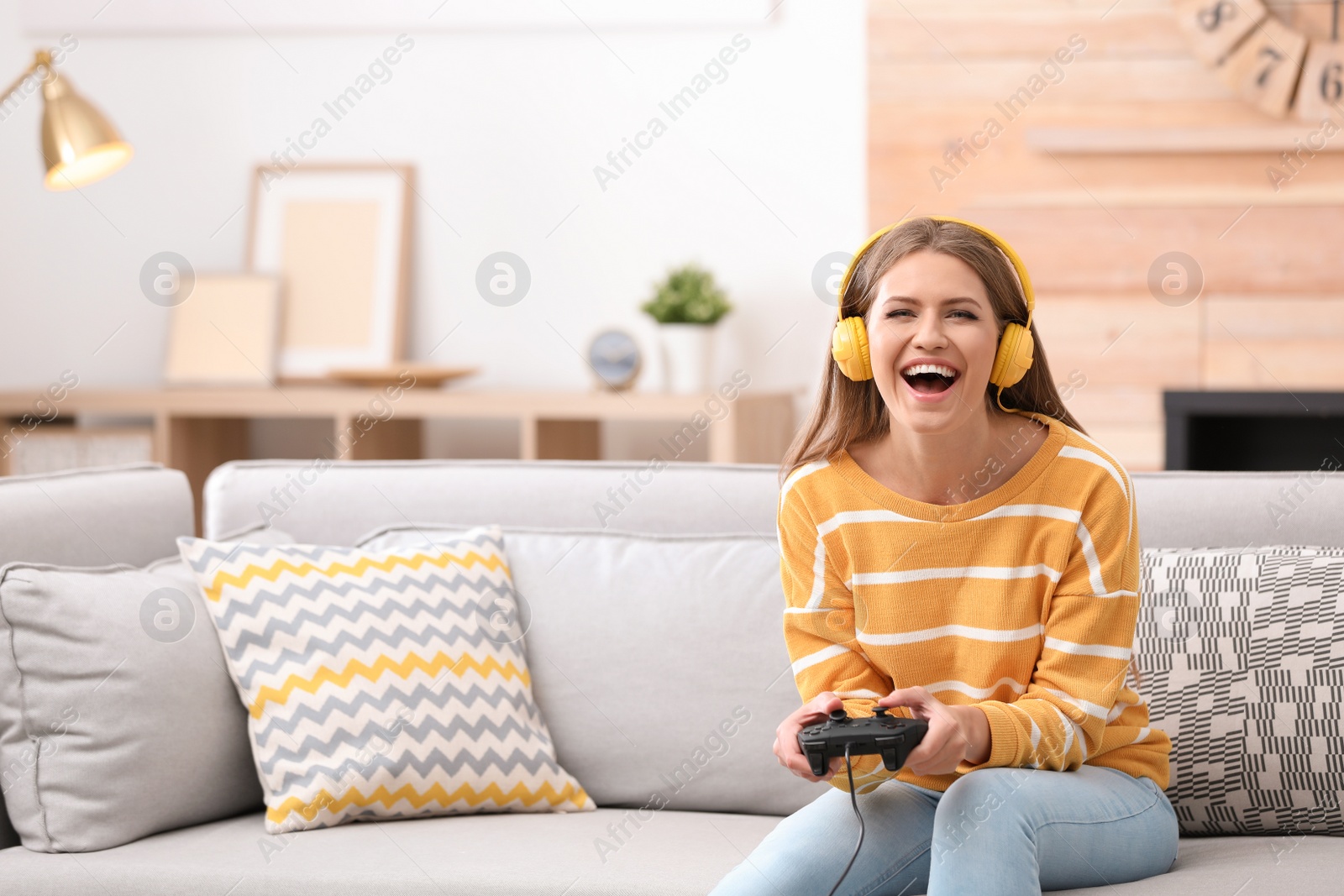 Photo of Emotional young woman playing video games at home