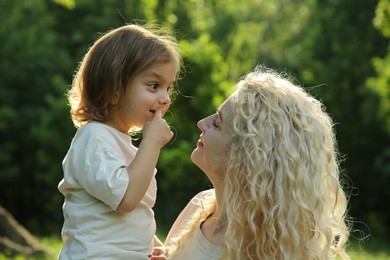 Photo of Beautiful woman with her daughter spending time together outdoors