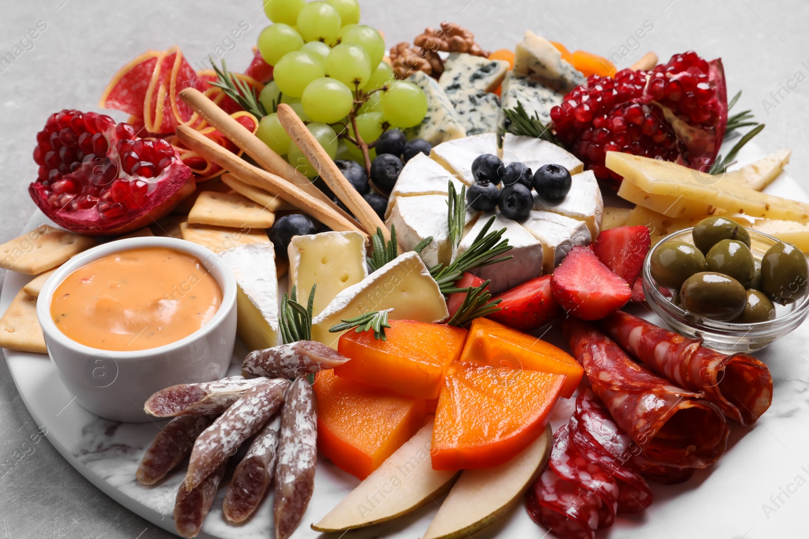 Photo of Assorted appetizers served on light grey table, closeup