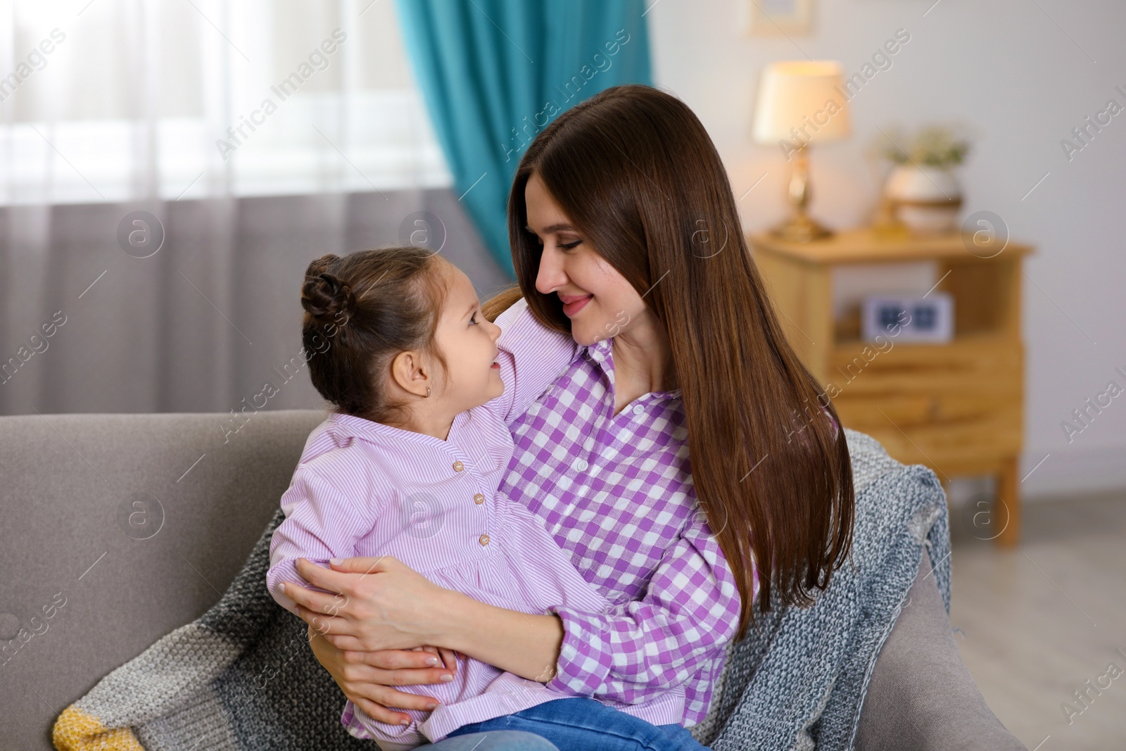 Photo of Young mother with little daughter at home