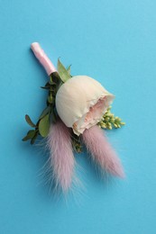 Photo of Small stylish boutonniere on light blue background, top view