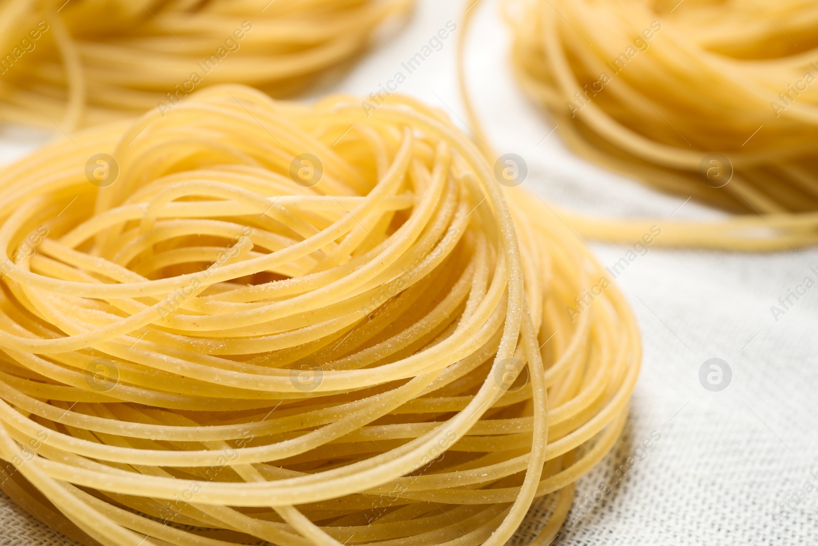 Photo of Capellini pasta on white tablecloth, closeup view