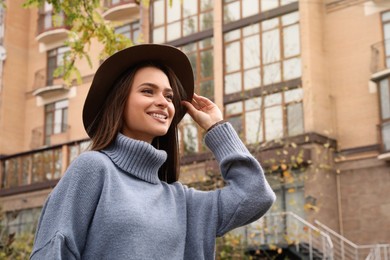 Photo of Beautiful young woman wearing stylish autumn clothes on city street