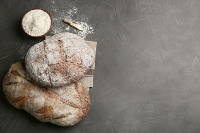 Photo of Tasty freshly baked bread on grey table, flat lay. Space for text