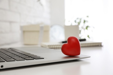 Photo of Red heart on laptop in office, space for text. Valentine's day celebration
