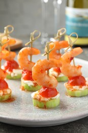 Tasty canapes with shrimps, vegetables and cream cheese on table, closeup