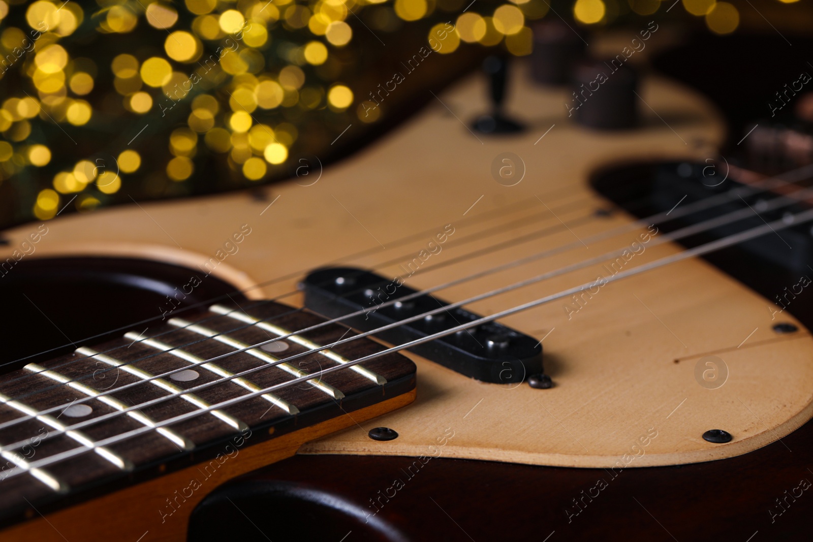Photo of Closeup view of guitar against blurred lights