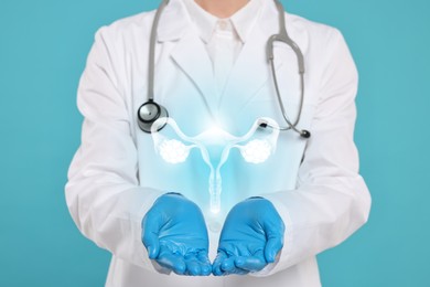 Image of Doctor and illustration of female reproductive system on light blue background, closeup