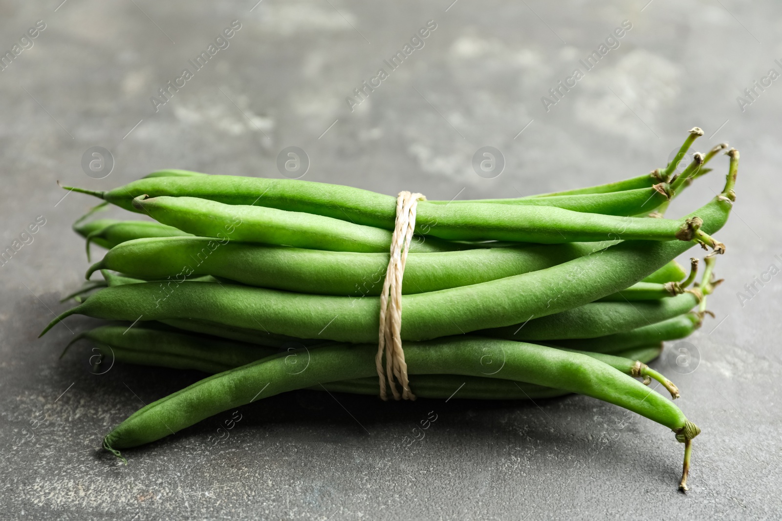 Photo of Fresh green beans on grey table, closeup