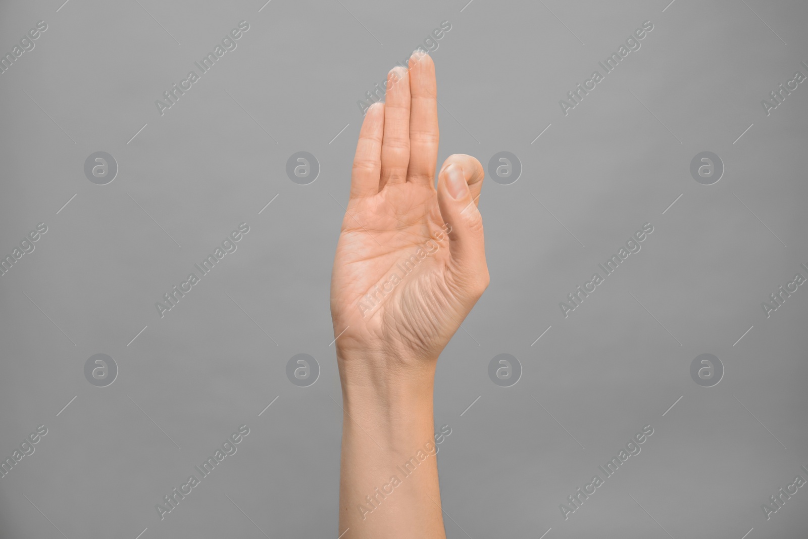 Photo of Woman showing F letter on grey background, closeup. Sign language