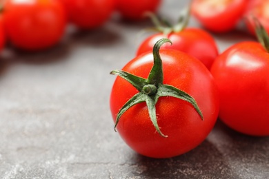 Photo of Fresh cherry tomatoes on stone background, closeup. Space for text