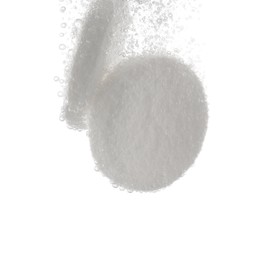 Effervescent pills dissolving in water on white background, closeup