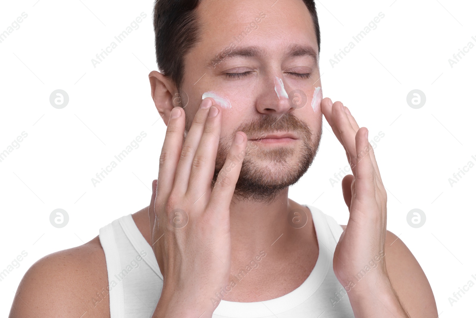 Photo of Man applying sun protection cream onto his face against white background