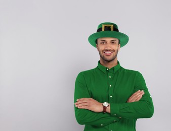 Image of St. Patrick's day party. Man with green leprechaun hat on grey background. Space for text