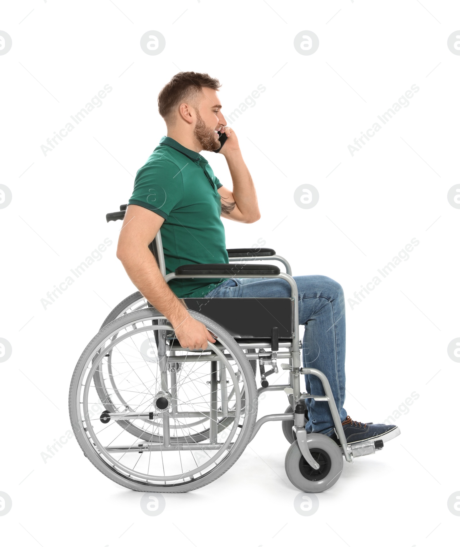 Photo of Young man in wheelchair talking by mobile phone isolated on white