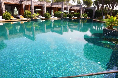 Outdoor swimming pool with umbrellas and sunbeds at resort