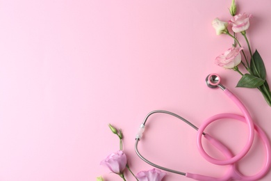 Photo of Flat lay composition with stethoscope and flowers on pink background, space for text. World health day