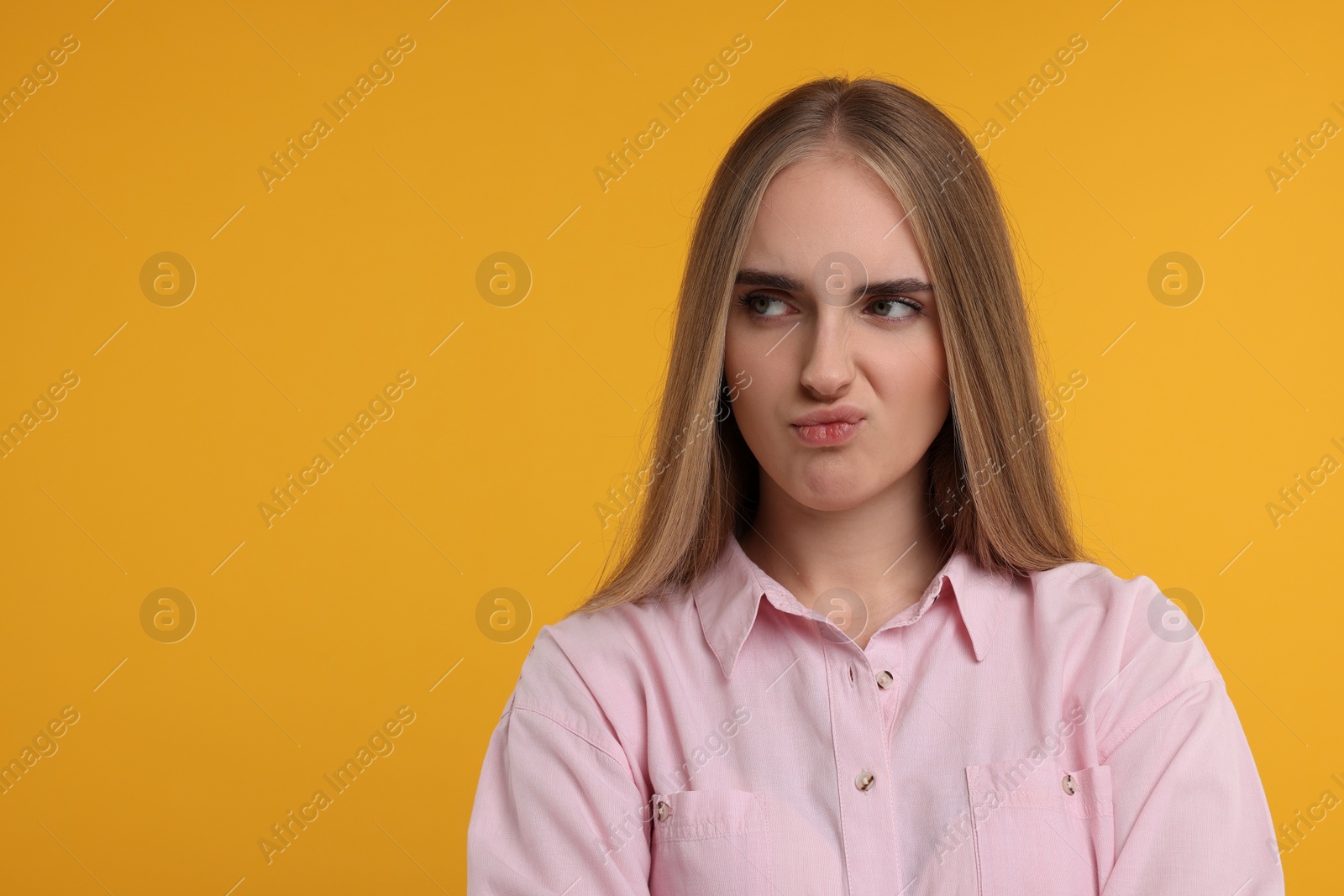 Photo of Resentful woman on orange background, space for text