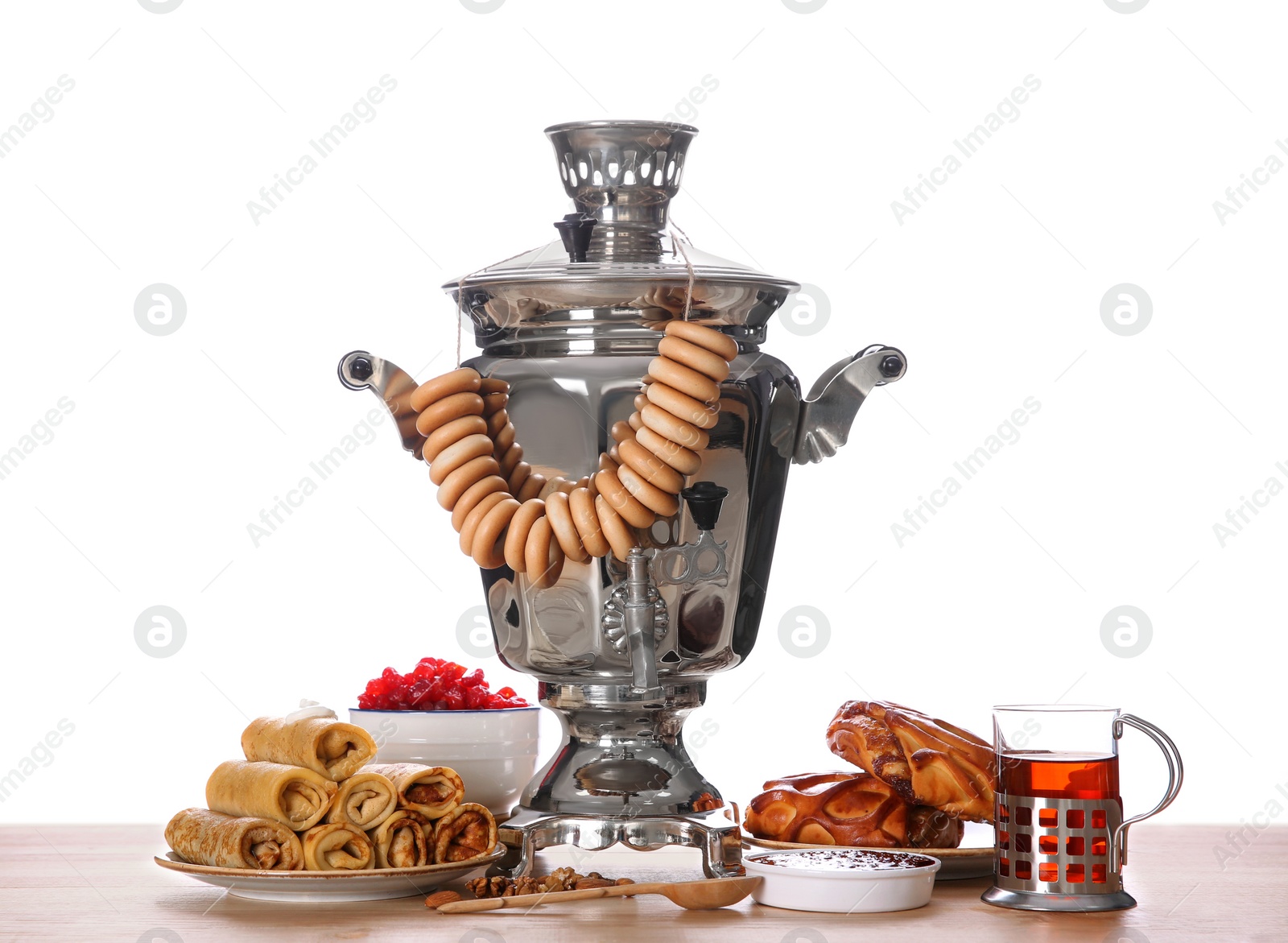 Photo of Traditional Russian samovar and treats on wooden table against white background