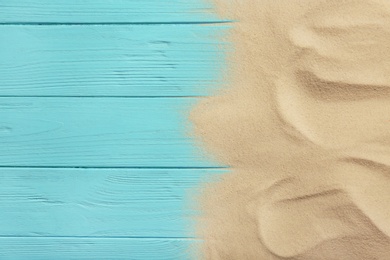 Photo of Beach sand on wooden background, top view with space for text