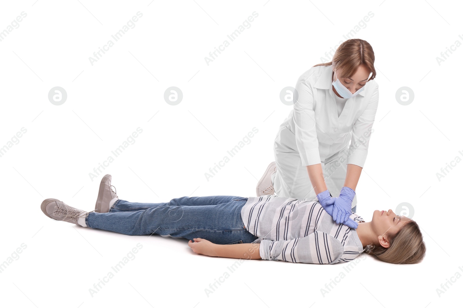 Photo of Doctor in uniform and protective mask performing first aid on unconscious woman against white background