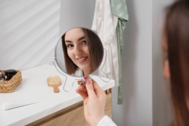 Beautiful woman looking in mirror in bathroom