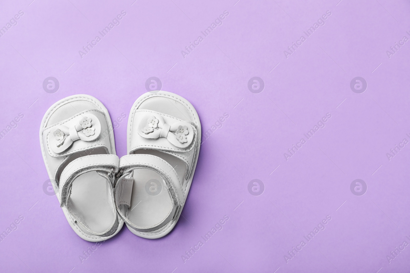 Photo of Pair of cute baby sandals on color background, top view