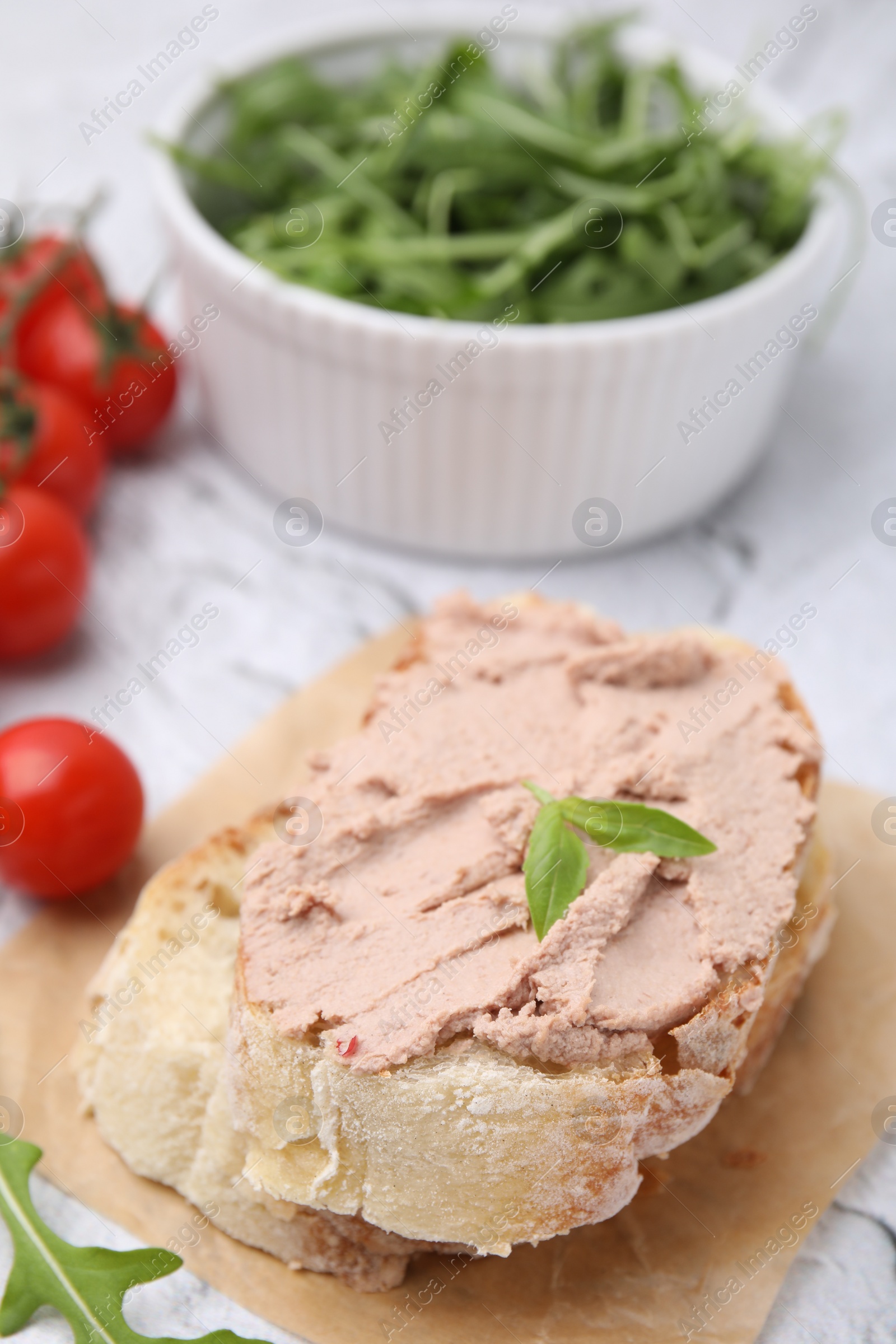 Photo of Delicious liverwurst sandwich with basil on white textured table