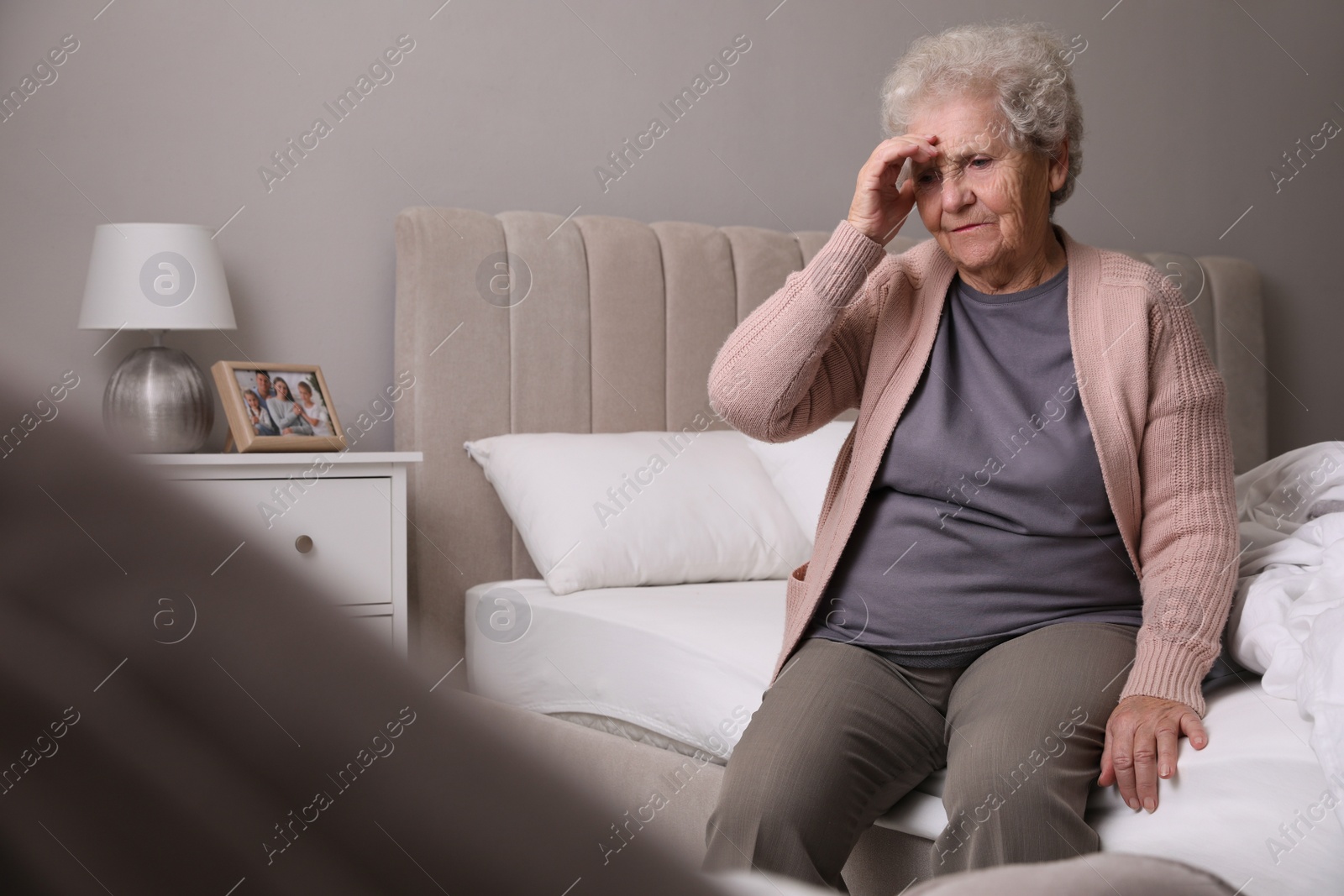 Photo of Senior woman with headache in bedroom at home