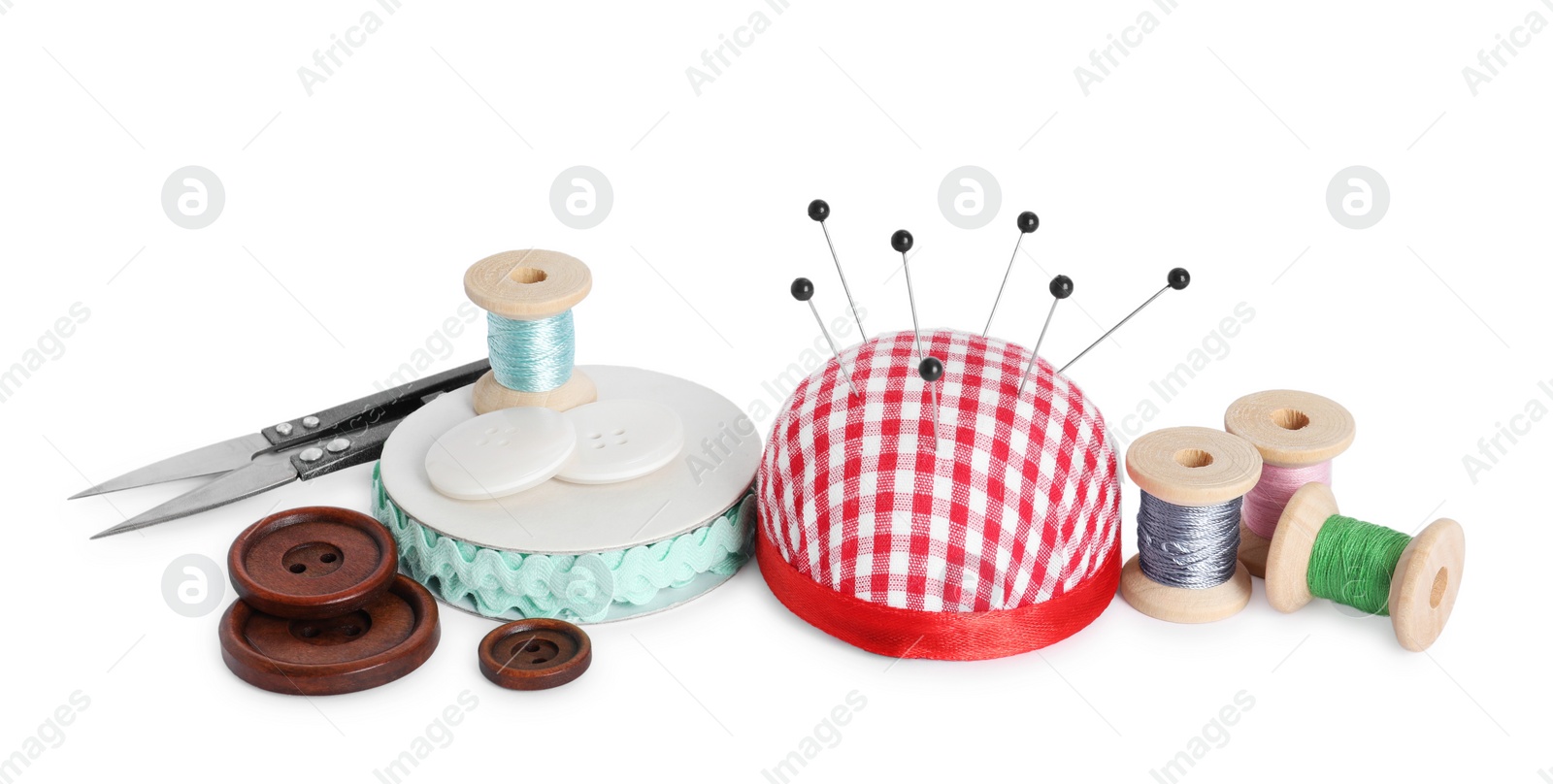 Photo of Pincushion, pins and other sewing tools isolated on white