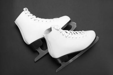 Photo of Pair of skates on black background, flat lay