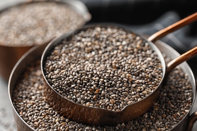 Saucepans with chia seeds on blurred background, closeup