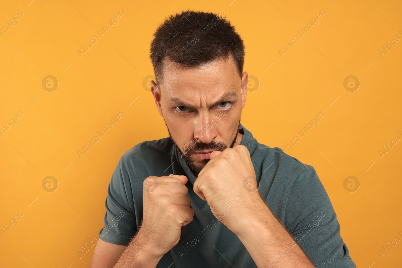 Photo of Man ready to fight on orange background