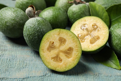 Photo of Fresh green feijoa fruits on blue wooden table, closeup